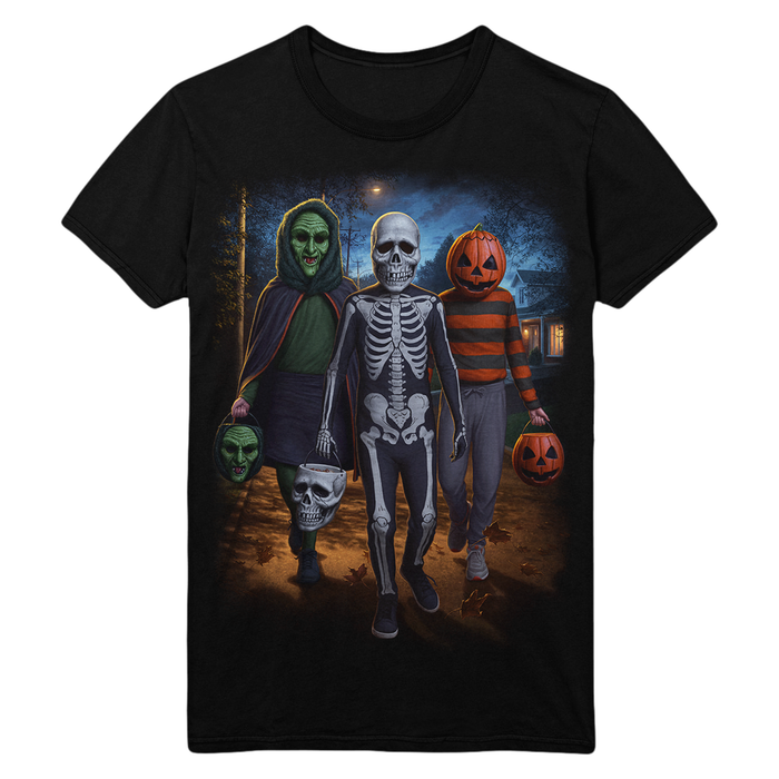 A black short-sleeve crewneck t-shirt featuring a large graphic print of three Halloween characters walking forward: a green-skinned figure in a cloak holding a mask, a central skeleton figure, and an orange-striped skeleton in a pumpkin costume holding a jack-o'-lantern.